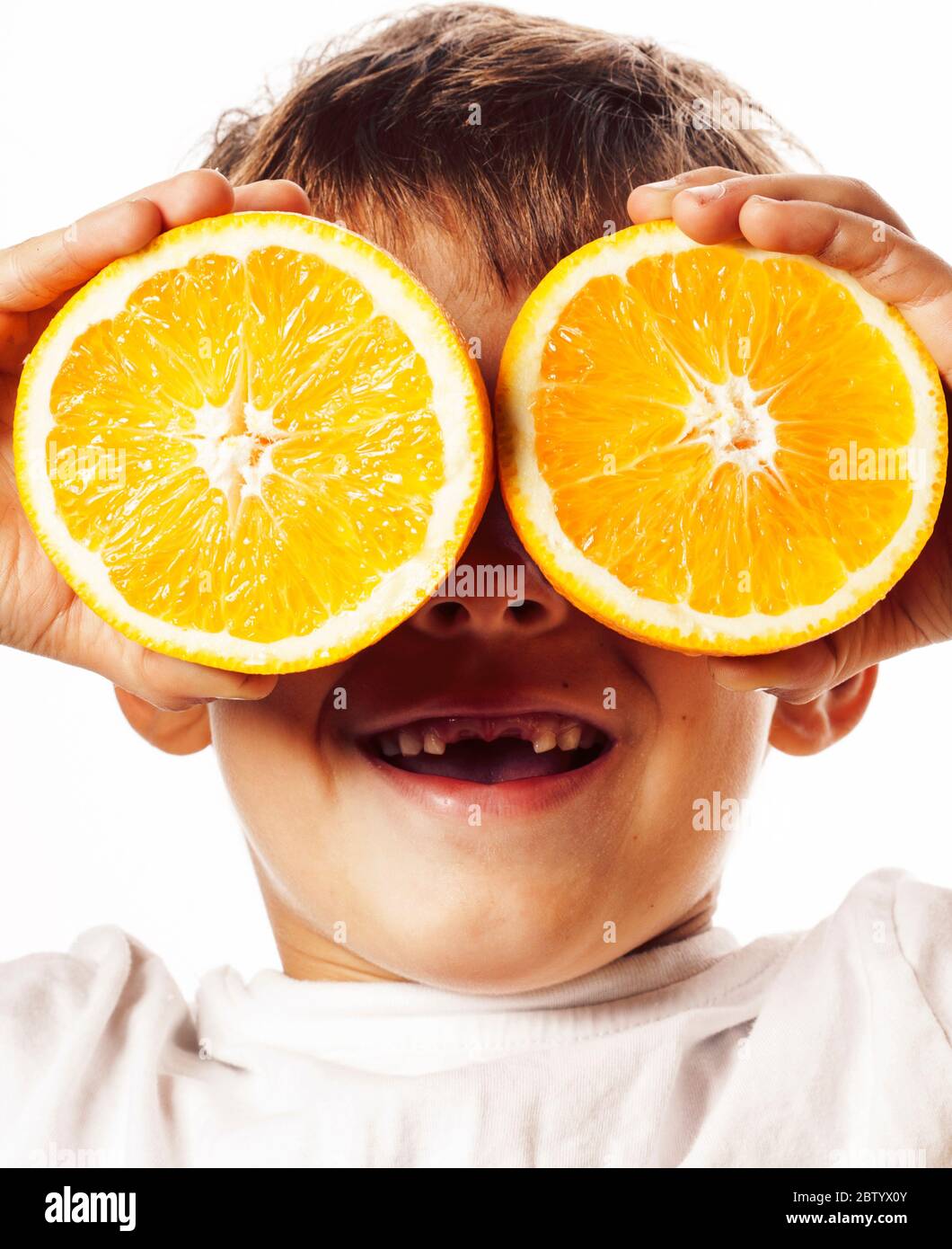 Poco carino Ragazzo con frutta di arancia doppio isolato su bianco sorridente senza denti frontali adorabili kid allegro Foto Stock