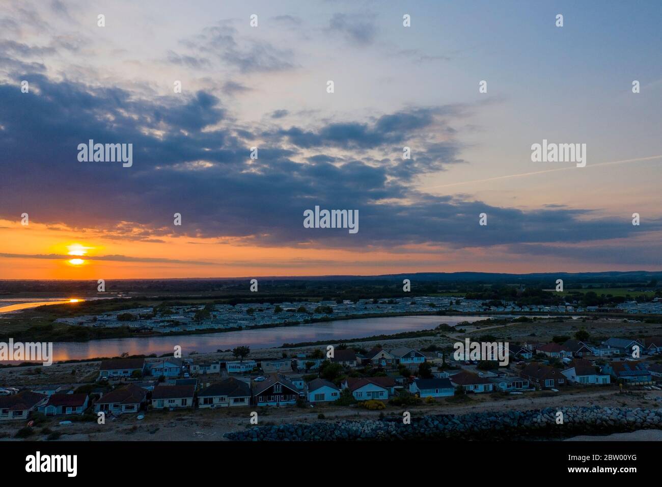 Splendido tramonto sulla laguna di Pagham con la riserva naturale sullo sfondo con il sole che affonda verso l'orizzonte e i colori che riflettono Foto Stock Splendido tramonto sulla laguna di Pagham con la riserva naturale sullo sfondo con il sole che affonda verso l'orizzonte e i colori che riflettono Foto Stock