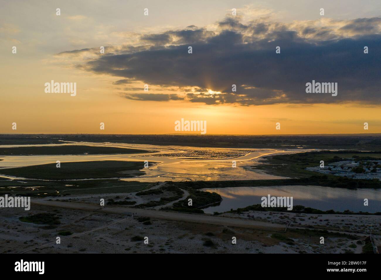 Splendido tramonto sulla Riserva Naturale di Pagham con i colori che si riflettono al largo del lago. Vista aerea. Foto Stock Splendido tramonto sulla Riserva Naturale di Pagham con i colori che si riflettono al largo del lago. Vista aerea. Foto Stock