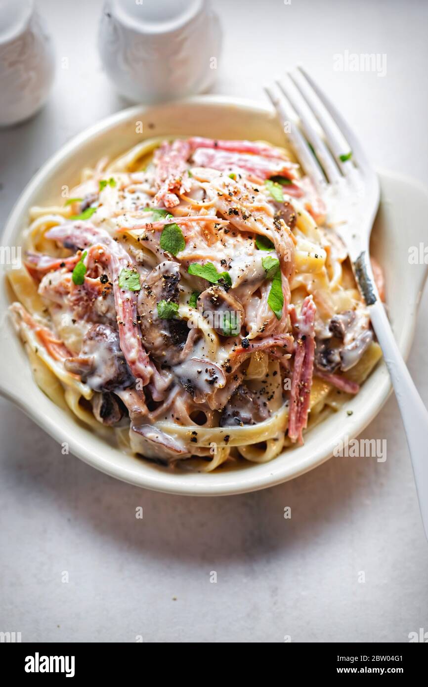 Tagliatelle di prosciutto e funghi, prezzemolo Foto Stock
