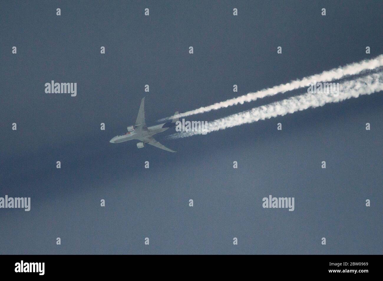 Glasgow, Scozia, Regno Unito. 28 Maggio 2020. Foto: FEDEX Boeing 777-FS2 volo da freighter FX4 (registrazione N895FDvisto volo in alto sulla Scozia a 37.000 metri a 505 km, volo da Memphis e diretto per Colonia consegna il trasporto di chi sa cosa? Visto lasciare lunghi contralti nel cielo profondo, con i suoi sentieri che gettano ombre sul velo molto sottile di nube strati sottostanti causato dall'angolo del sole rende una vista interessante. Credit: Colin Fisher/Alamy Live News Foto Stock