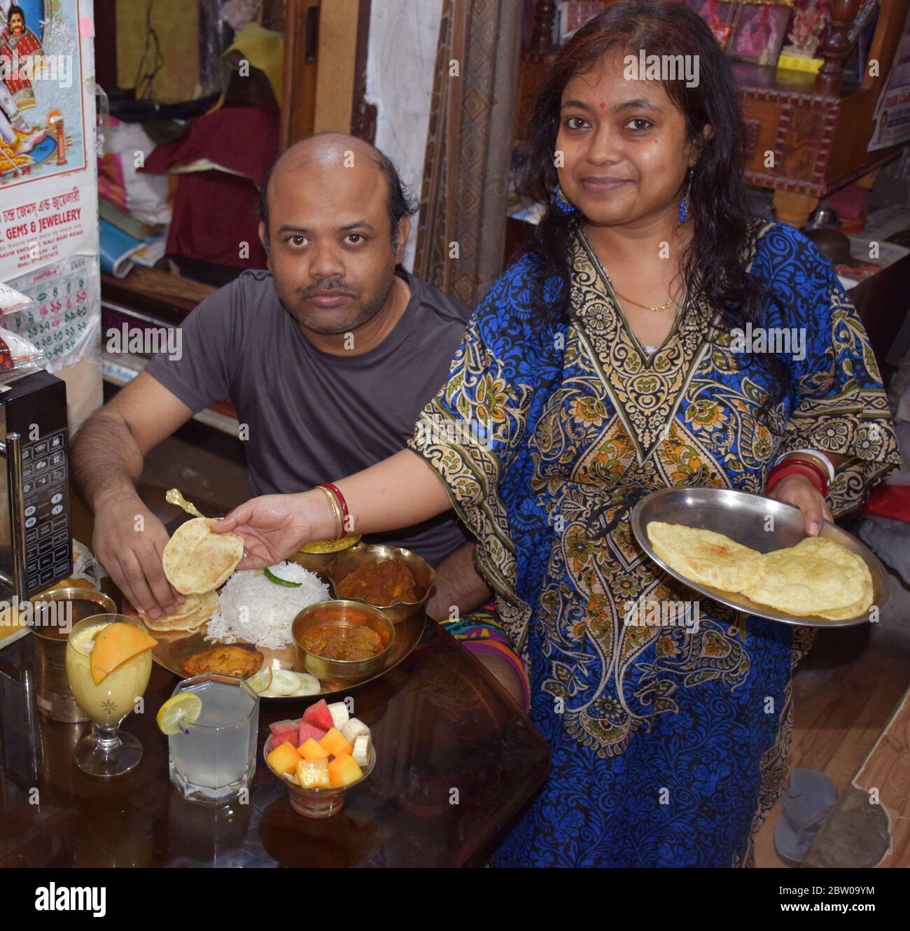 L'uomo indiano bengalese mangia cibo mentre sua moglie serve cibo durante il rituale Jamai Soshti Foto Stock