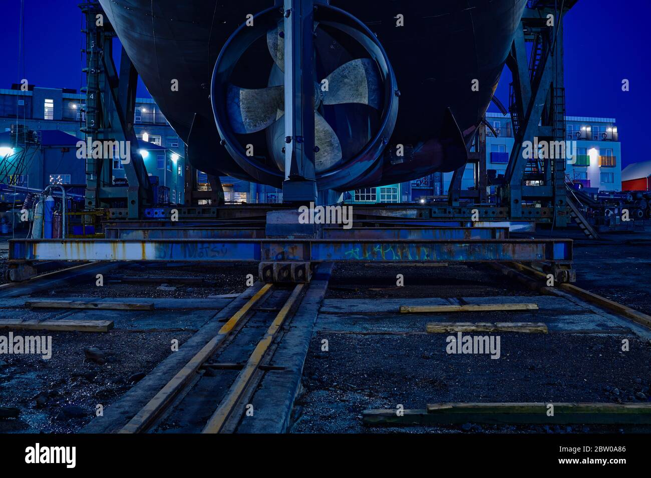 Nave nel vecchio cantiere navale del porto di Reykjavík nel mezzo di una notte estiva, blu drammatico e luci sul rotore Foto Stock