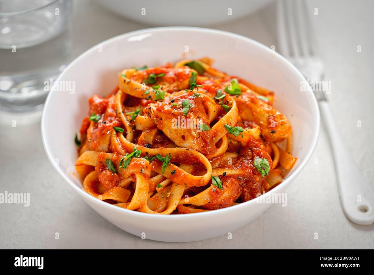 Tagliatelle di pollo con salsa di pomodoro e prezzemolo Foto Stock