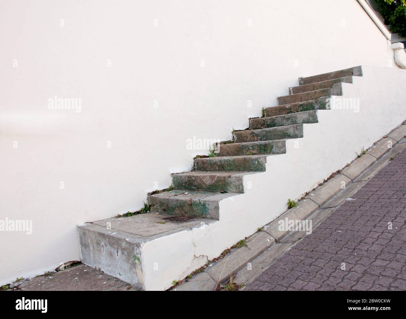 Undici gradini concreti che salgono su un muro, salendo da nessuna parte Foto Stock