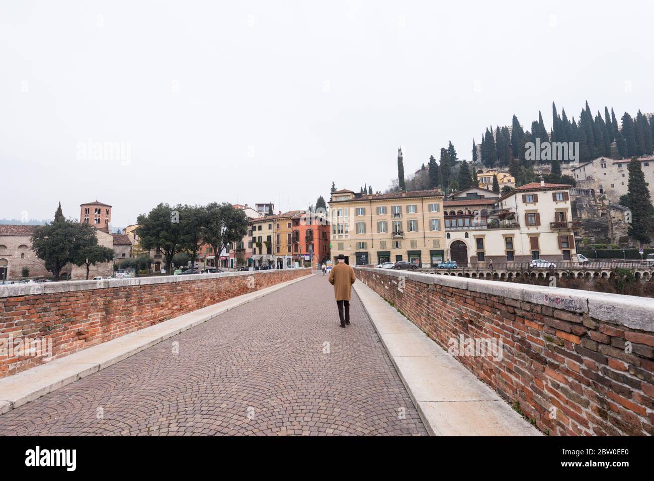 VERONA, ITALIA - 14 MARZO 2018: Immagine orizzontale di un pedone che attraversa Ponte pietra, famoso ponte di Verona Foto Stock