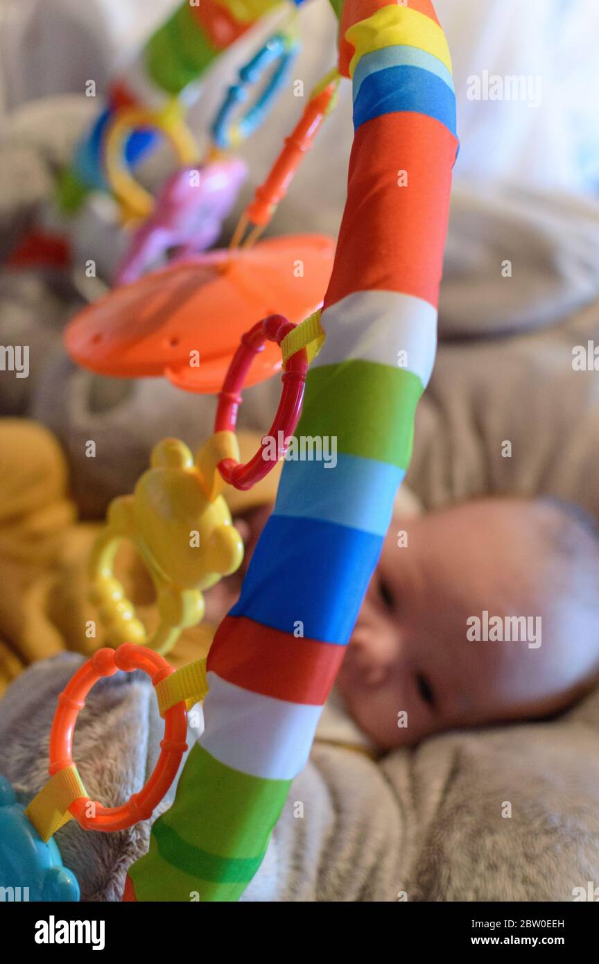 Blurred Baby giocando attivamente nel suo parco giochi Rainbow. Foto Stock