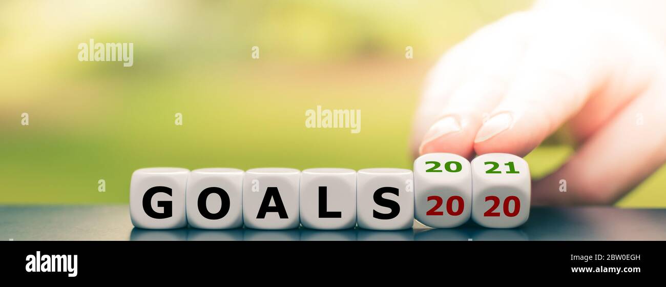 La mano fa girare i dadi e cambia l'espressione "goal 2020" in "goal 2021" Foto Stock