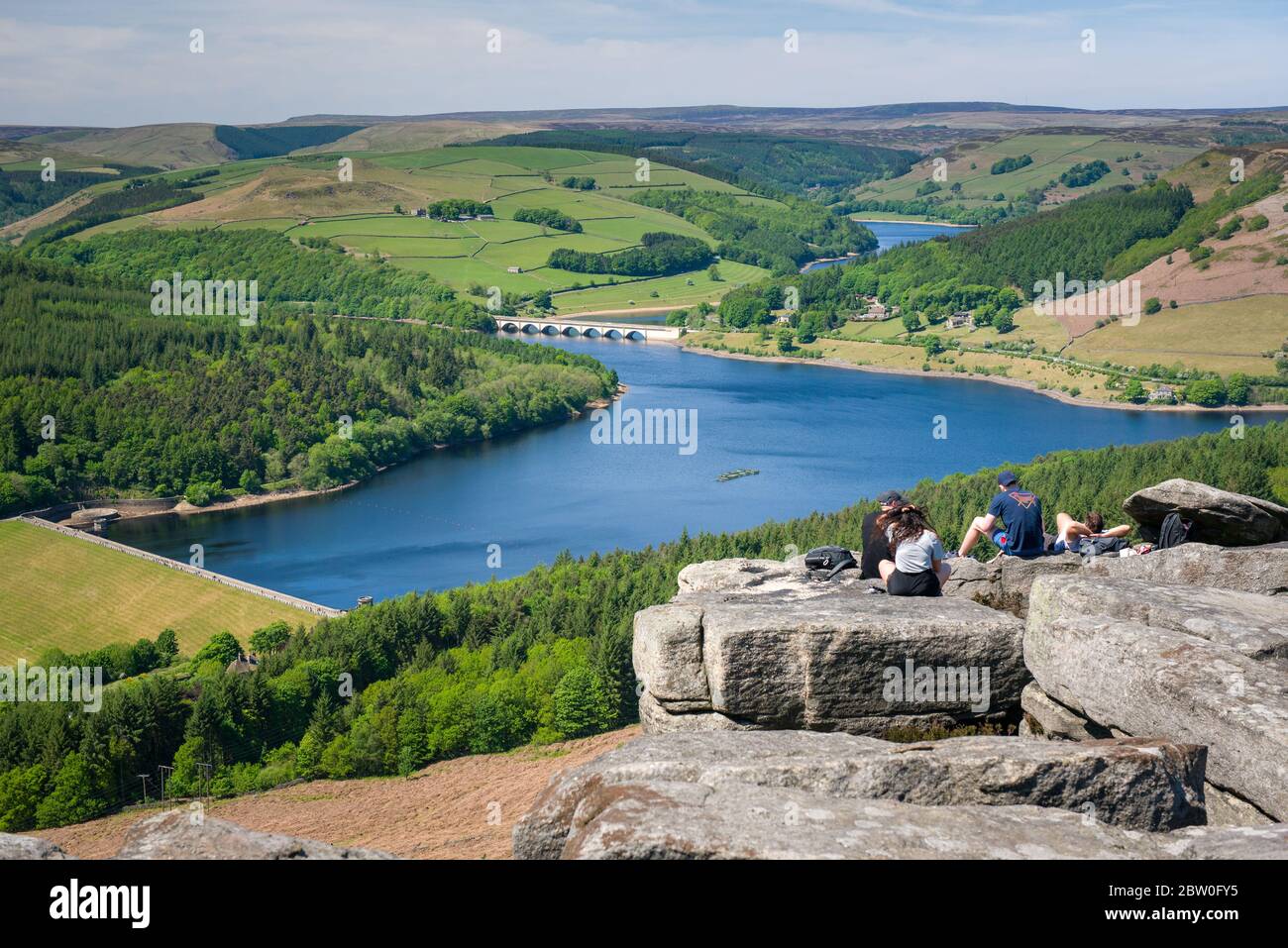 Vista da Bamford Edge verso il lago artificiale Ladybower con persone che si siedono/arrampicano/si godono la giornata dopo che il blocco del coronavirus è stato alleggerito Foto Stock