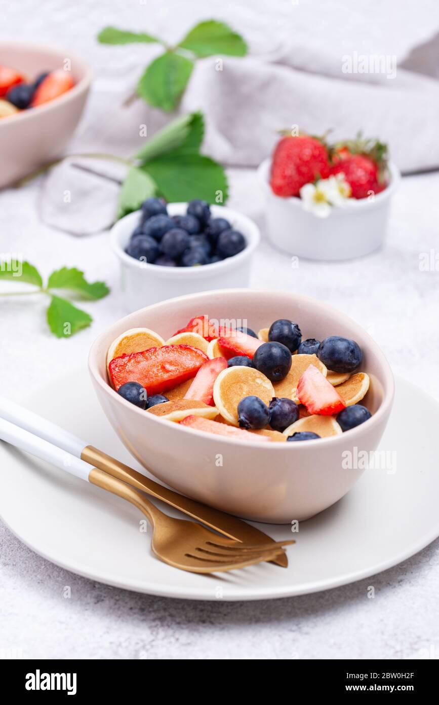 Cereali dolci e minuscoli pancake con frutti di bosco Foto Stock