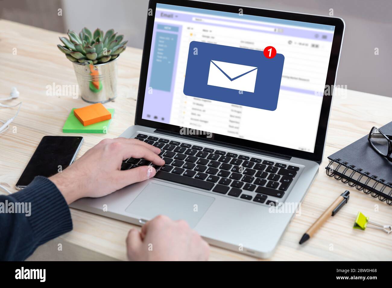 Concetto di notifica e-mail, uomo che lavora con un computer portatile, un nuovo messaggio e-mail in arrivo sullo schermo, sfondo ufficio aziendale Foto Stock