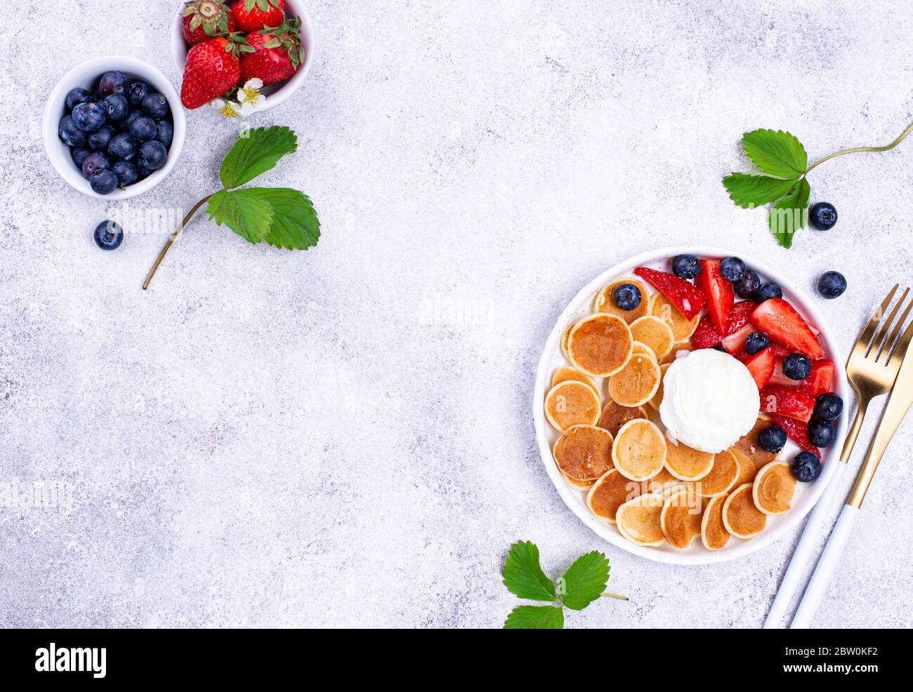 Cereali dolci e minuscoli pancake con frutti di bosco Foto Stock