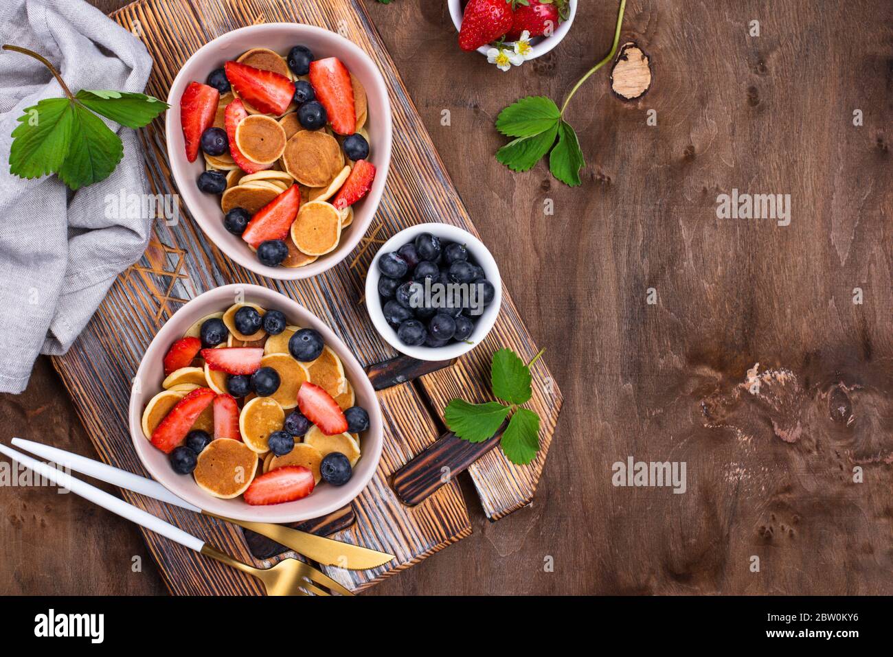 Cereali dolci e minuscoli pancake con frutti di bosco Foto Stock