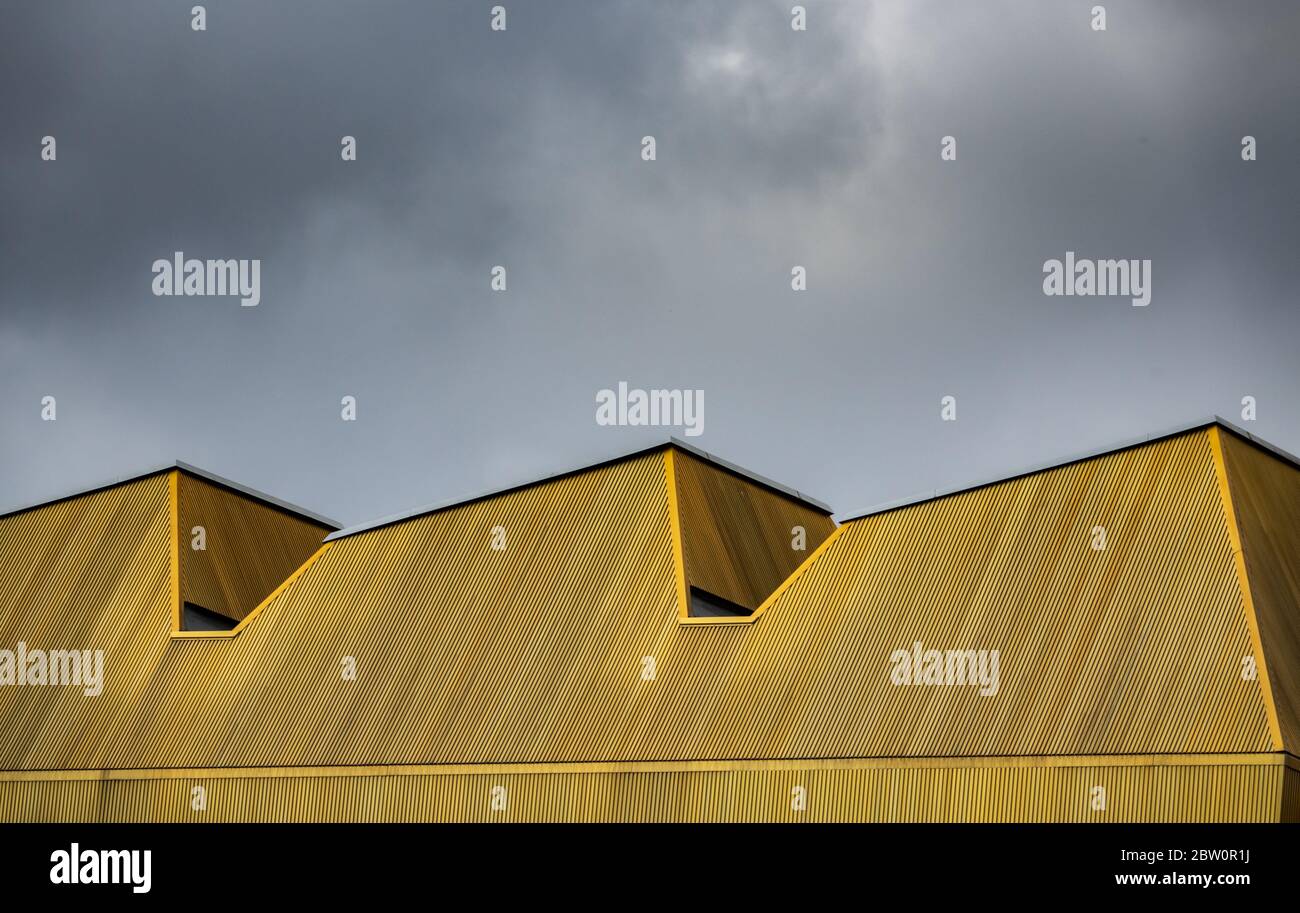 Architettura astratta immagine di un tetto giallo urbano moderno contro un cielo nuvoloso Foto Stock