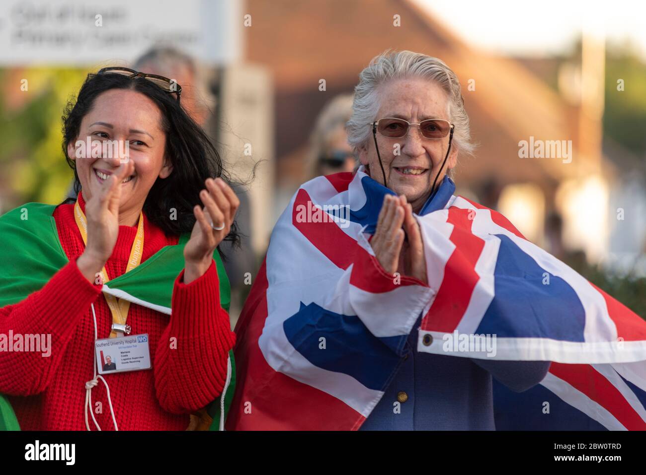 Ultimo clap per gli accompagnatori al Southend University Hospital, Essex, Regno Unito alle 20:00 di giovedì sera. I cittadini che battono bandiere nazionali Foto Stock