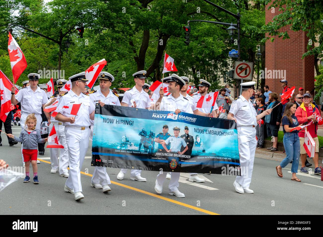 Saint John, New Brunswick, Canada - 1 luglio 2019: Gli ufficiali navali partecipano alla sfilata del Canada Day. Il portare un banner di reclutamento. Foto Stock