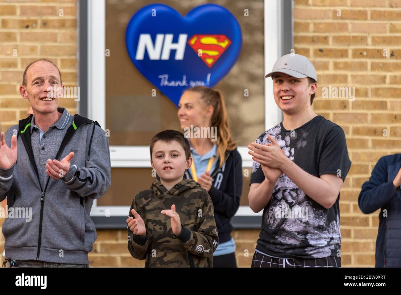 Ultimo clap per gli accompagnatori alle 20:00 giovedì fuori dal Southend University Hospital, Essex, Regno Unito. I membri del pubblico che battono sotto NHS Superhero ti ringraziano Foto Stock
