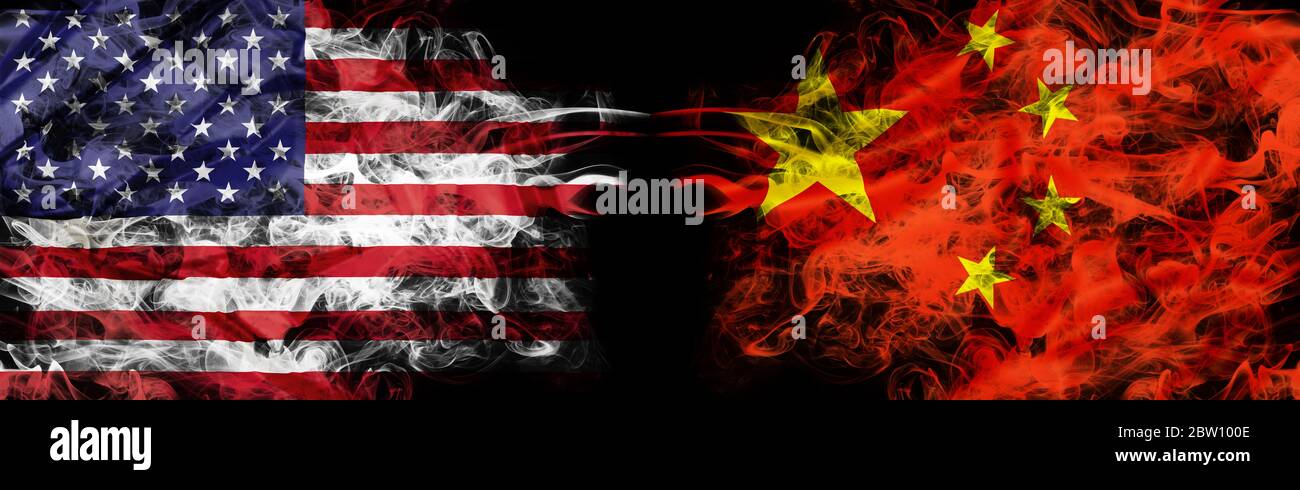 Bandiere americane e cinesi a forma di fumo su sfondo nero. Concetto di guerra di conflitto e dovere di usanza. Metafora America vs Cina. Yuan dollaro Foto Stock