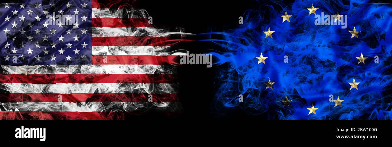 Bandiera americana ed europea in fumo su sfondo nero. Concetto di conflitto e dovere di usanza. Metafora America vs Europa. Cambio Euro in dollari Foto Stock
