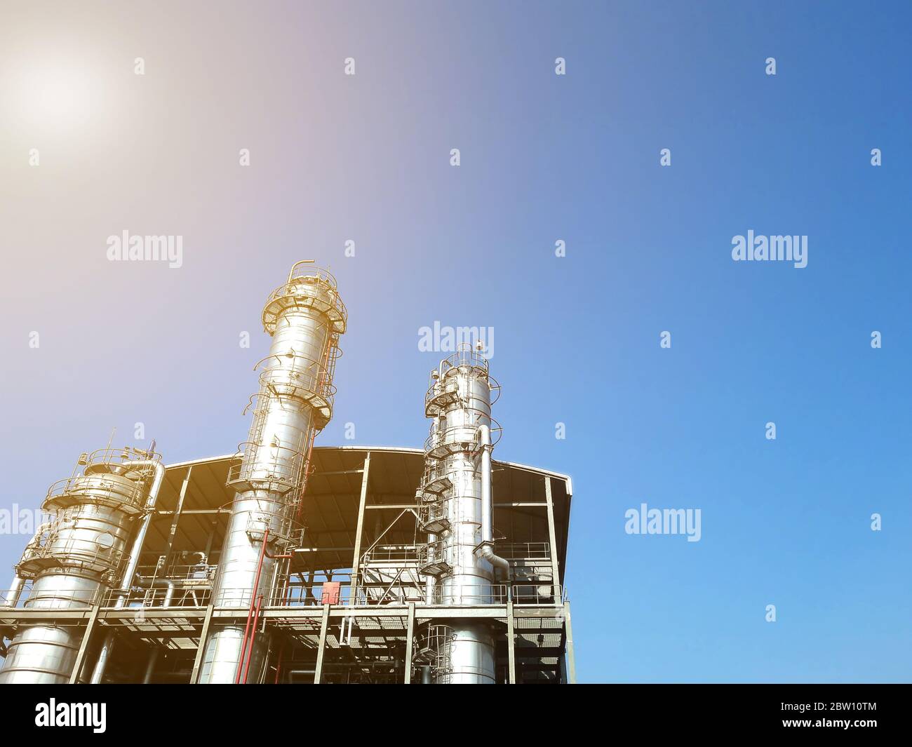 Colonna di distillazione di impianti di raffineria su cielo blu bello, concetto industriale. Foto Stock