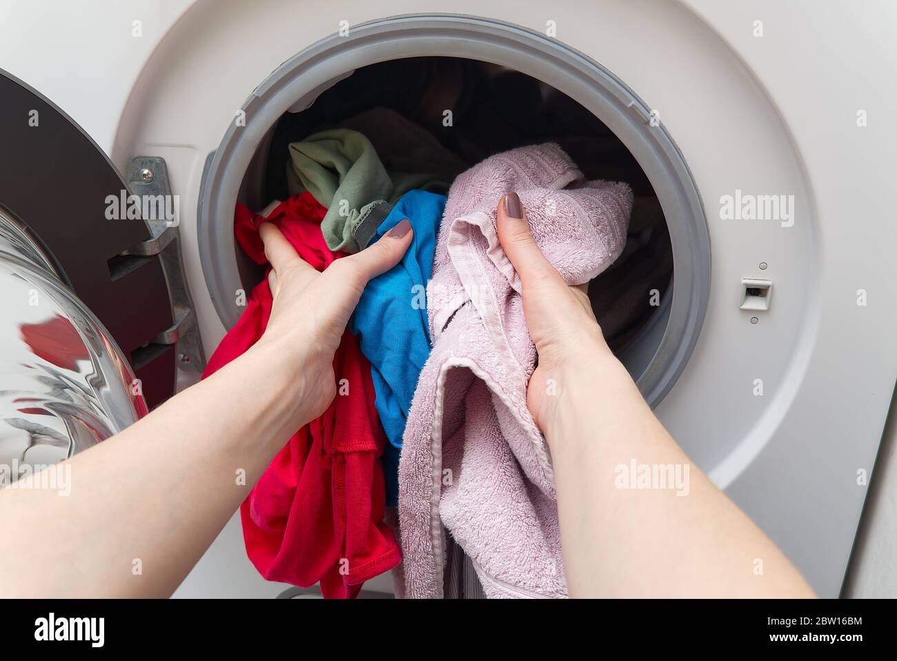 lavatrice bianca a caricamento frontale, piena di vestiti. lavanderia per  la pulizia. lavanderia sporca nella lavatrice Foto stock - Alamy