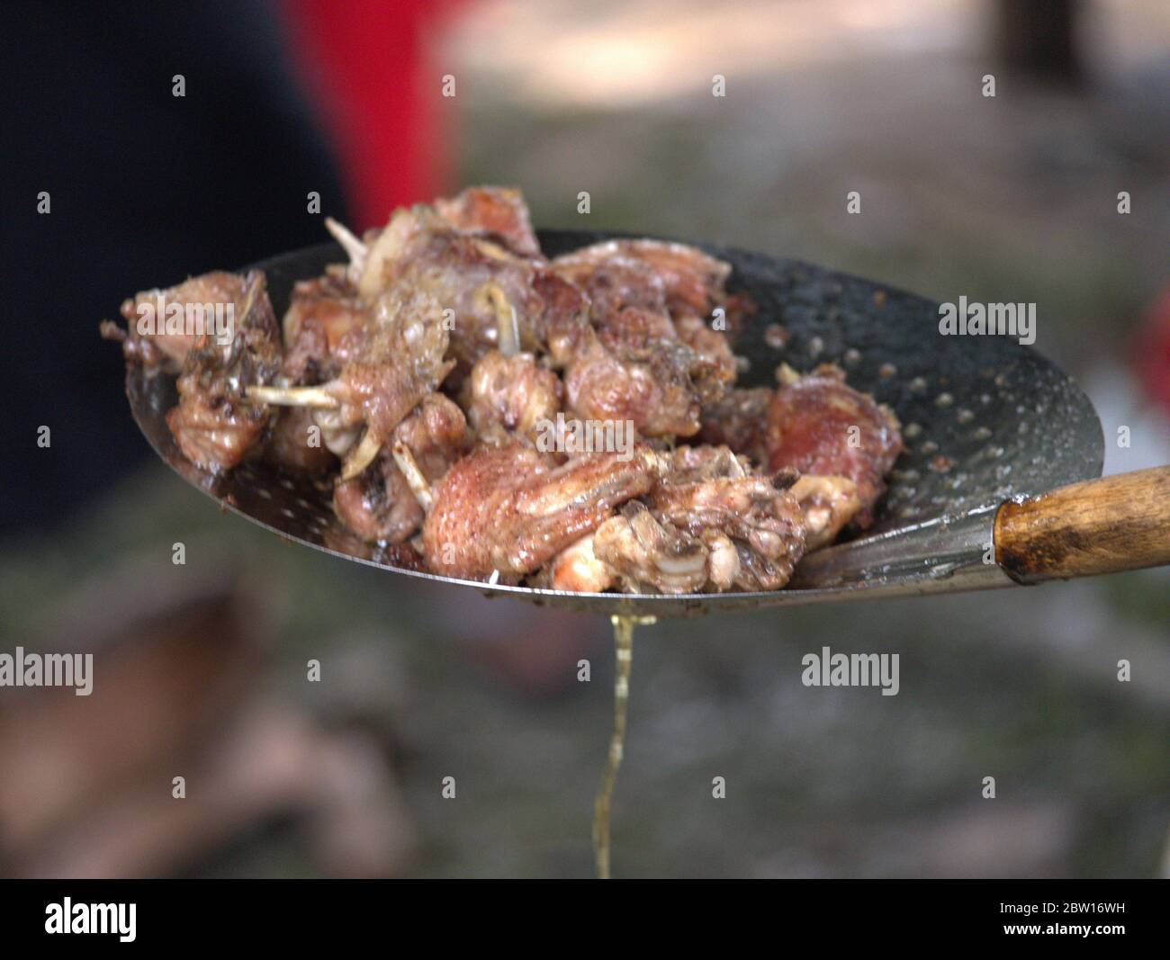 La carne di pollo viene prelevata dal wok Foto Stock