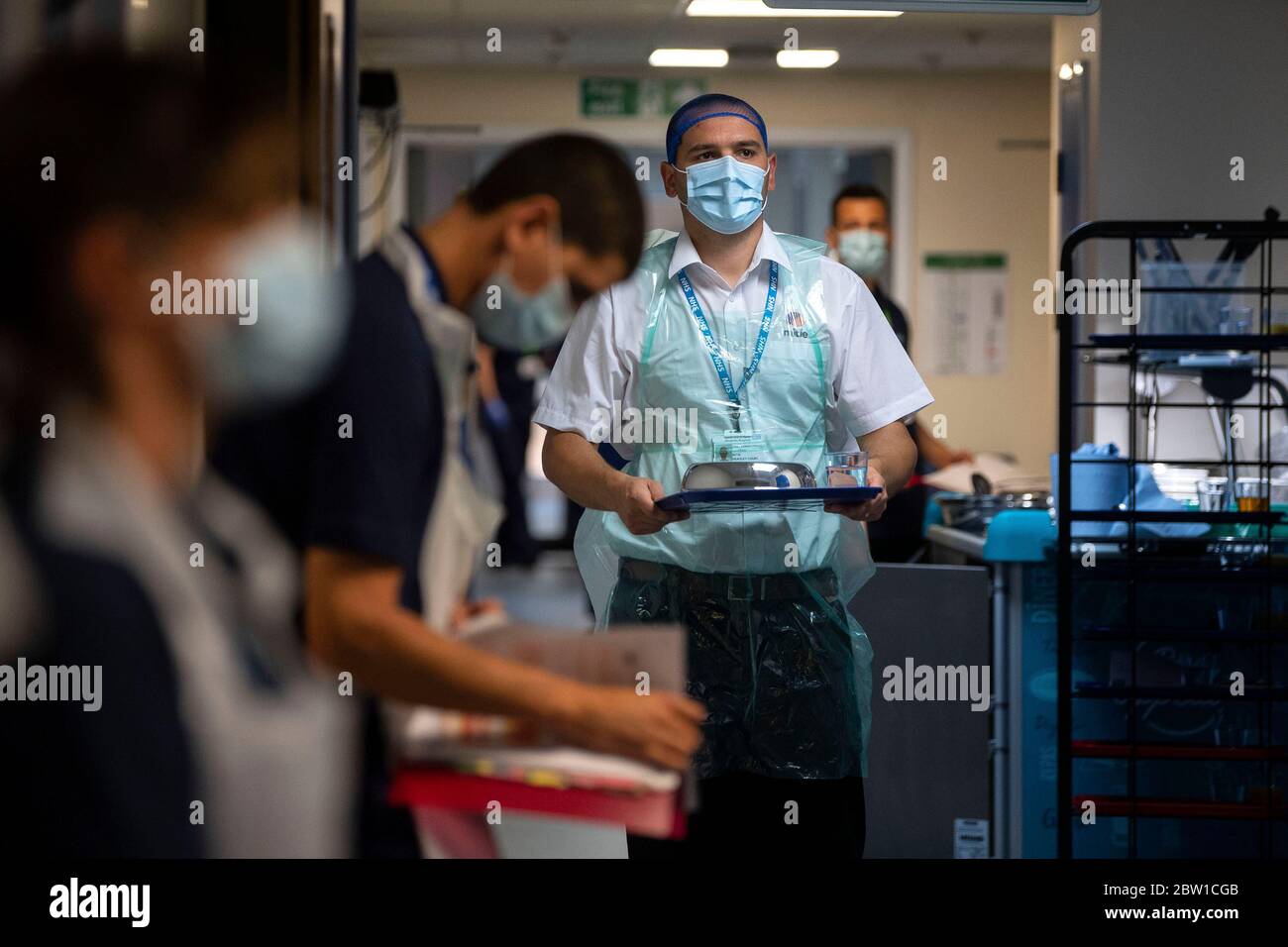 Un membro del personale di catering prende un pasto ad un paziente, poiché i primi pazienti sono ammessi al Centro NHS Seacole di Headley Court, Surrey, un ospedale militare disusato, che è stato convertito durante la pandemia del coronavirus. Chiamata in onore dell'infermiera giamaicana, Mary Seacole, la struttura aiuterà a curare e sostenere i pazienti che si stanno riprendendo dal COVID-19 e che non hanno più bisogno di cure in un ospedale acuto, o coloro che hanno COVID e non possono più affrontare i loro sintomi a casa. Foto Stock