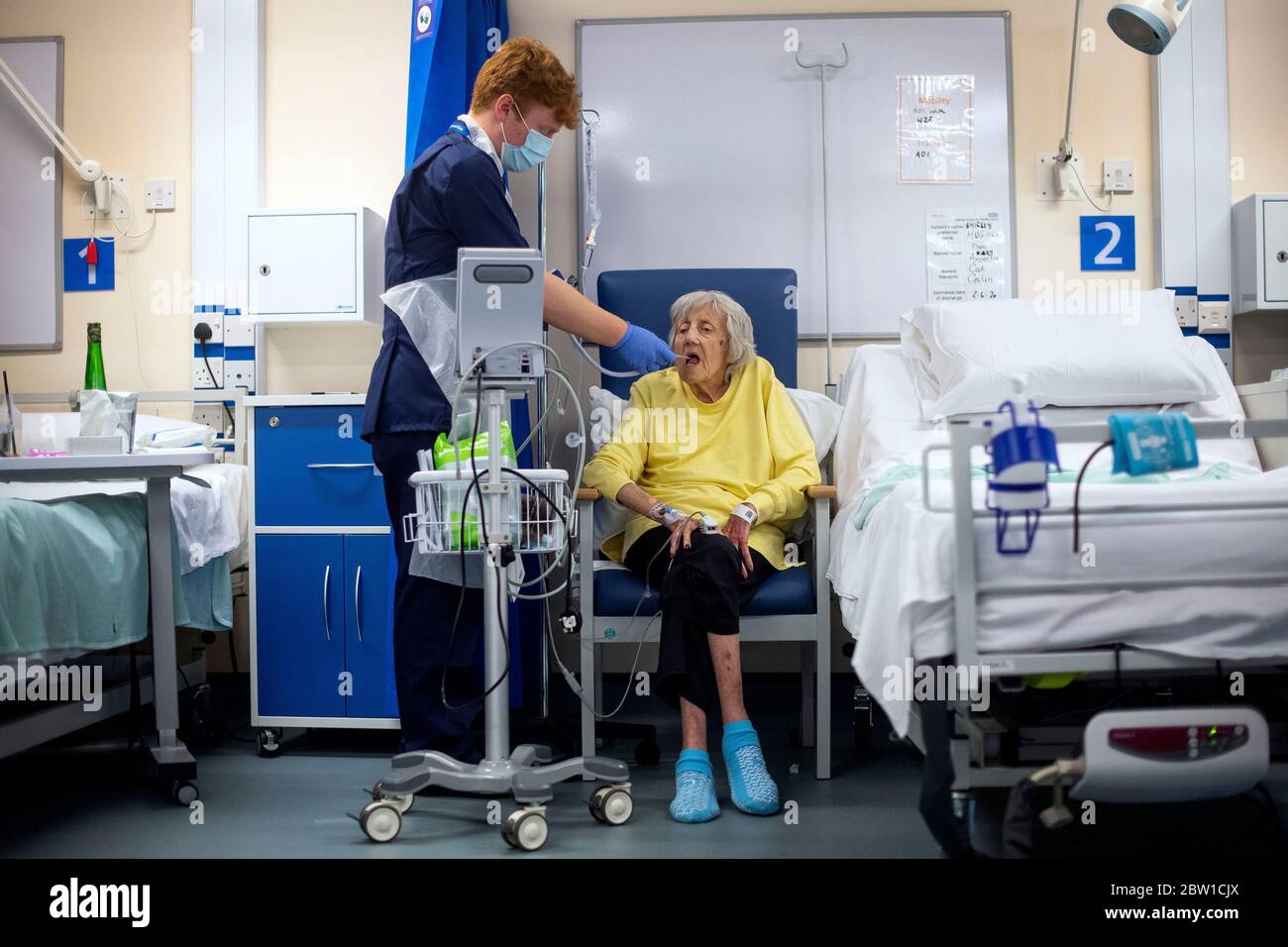 Un addetto al supporto Rehab controlla il paziente Shirley Hughes, 86, poiché i primi pazienti sono ricoverati al Centro NHS Seacole di Headley Court, Surrey, un ospedale militare disusato, che è stato convertito durante la pandemia del coronavirus. Chiamata in onore dell'infermiera giamaicana, Mary Seacole, la struttura aiuterà a curare e sostenere i pazienti che si stanno riprendendo dal COVID-19 e che non hanno più bisogno di cure in un ospedale acuto, o coloro che hanno COVID e non possono più affrontare i loro sintomi a casa. Foto Stock