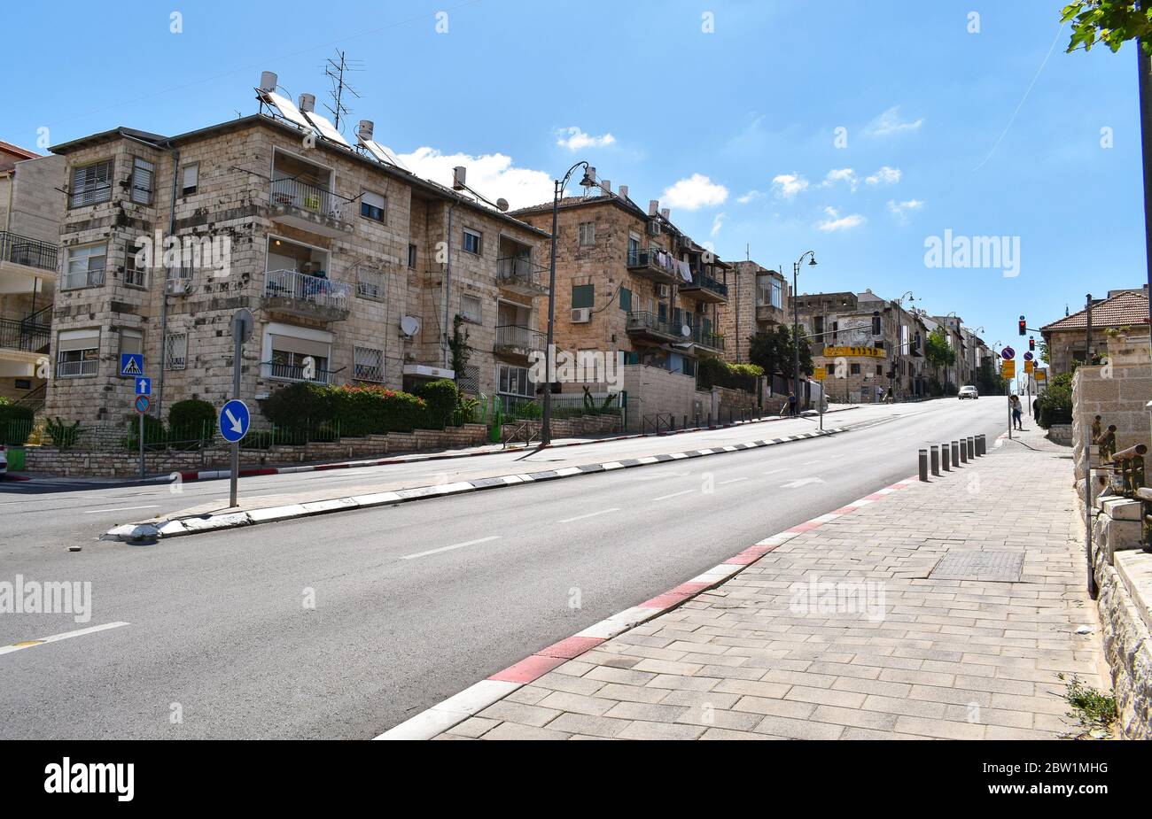 Quasi vuota strada a Nakhalat Tsiyon a gerusalemme israele durante il virus corona covid pandemia blocco con un cielo chiaro e alcune nuvole nella ba Foto Stock