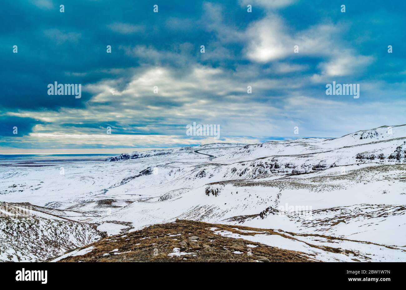 Spettacolari nuvole su neve coperta paesaggio di montagna con strada in lo sfondo Foto Stock