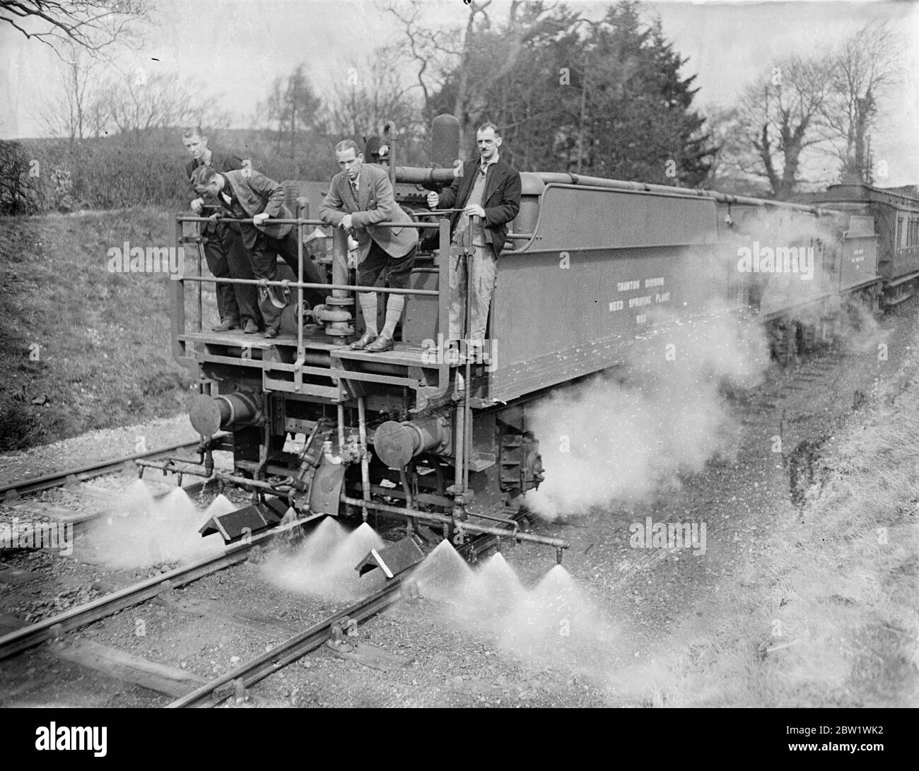 Great Western Railway lancia la campagna di uccisione delle erbacce 'gratta loro con 'Spare' Express. Il 'Spare' Express, e voi addestrate che infligge la morte a 20 miglia all'ora alle erbacce che crescono sulle linee della Great Western Railways, ha iniziato a lavorare nel distretto di Oswestry dello Shropshire. Il treno è composto da un motore, tre gare di locomotori, che detengono 9 1/2 mila galloni di acqua che sono stati convertiti in enormi 'lattine d'acqua' con getti regolabili, un carro armato che contiene 2000 galloni di sostanza chimica in soluzione concentrata, e protegge il furgone del freno. Soluzione una sei parte di acqua ad una parte di killer erbaccia Foto Stock