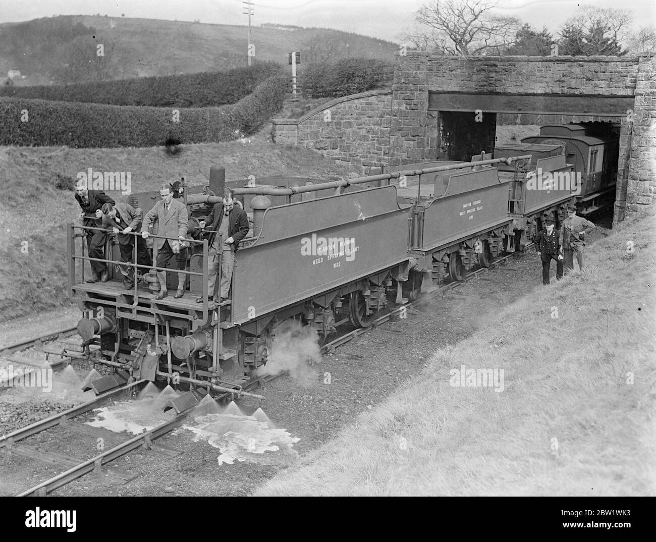 Great Western Railway lancia la campagna di uccisione delle erbacce 'gratta loro con 'Spare' Express. Il 'Spare' Express, e voi addestrate che infligge la morte a 20 miglia all'ora alle erbacce che crescono sulle linee della Great Western Railways, ha iniziato a lavorare nel distretto di Oswestry dello Shropshire. Il treno è composto da un motore, tre gare di locomotori, che detengono 9 1/2 mila galloni di acqua che sono stati convertiti in enormi 'lattine d'acqua' con getti regolabili, un carro armato che contiene 2000 galloni di sostanza chimica in soluzione concentrata, e protegge il furgone del freno. Soluzione una sei parte di acqua ad una parte di killer erbaccia Foto Stock