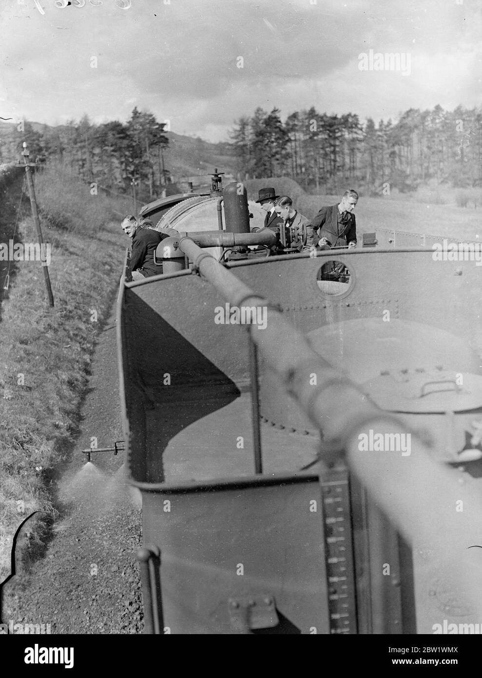 Great Western Railway lancia la campagna di uccisione delle erbacce 'gratta loro con 'Spare' Express. Il 'Spare' Express, e voi addestrate che infligge la morte a 20 miglia all'ora alle erbacce che crescono sulle linee della Great Western Railways, ha iniziato a lavorare nel distretto di Oswestry dello Shropshire. Il treno è composto da un motore, tre gare di locomotori, che detengono 9 1/2 mila galloni di acqua che sono stati convertiti in enormi 'lattine d'acqua' con getti regolabili, un carro armato che contiene 2000 galloni di sostanza chimica in soluzione concentrata, e protegge il furgone del freno. Soluzione una sei parte di acqua ad una parte di killer erbaccia Foto Stock