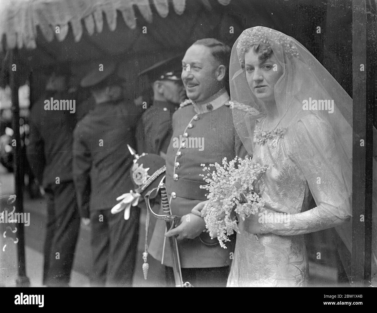 Lady Sylvia Maitland si sposò con Lord Carew a St Margaret's. Lady Sylvia Maitland, unica figlia del conte e contessa di Lauderdale, si sposò alla chiesa di St Margaret, a Westminster, con Lord Carew, il duca di Fanteria leggera della Cornovaglia. La sposa indossava una abito di broccato d'oro e seguiva dodici bridesmaid che indossavano camici di morbido materiale bianco rifiniti con ceneri d'oro per adattarsi all'abito della sposa. [Sposato contemporaneamente al Duca di Windsor. Londra Wedding rush.] Foto: La sposa sorridente e lo sposo dopo la cerimonia. 3 giugno 1937 Foto Stock