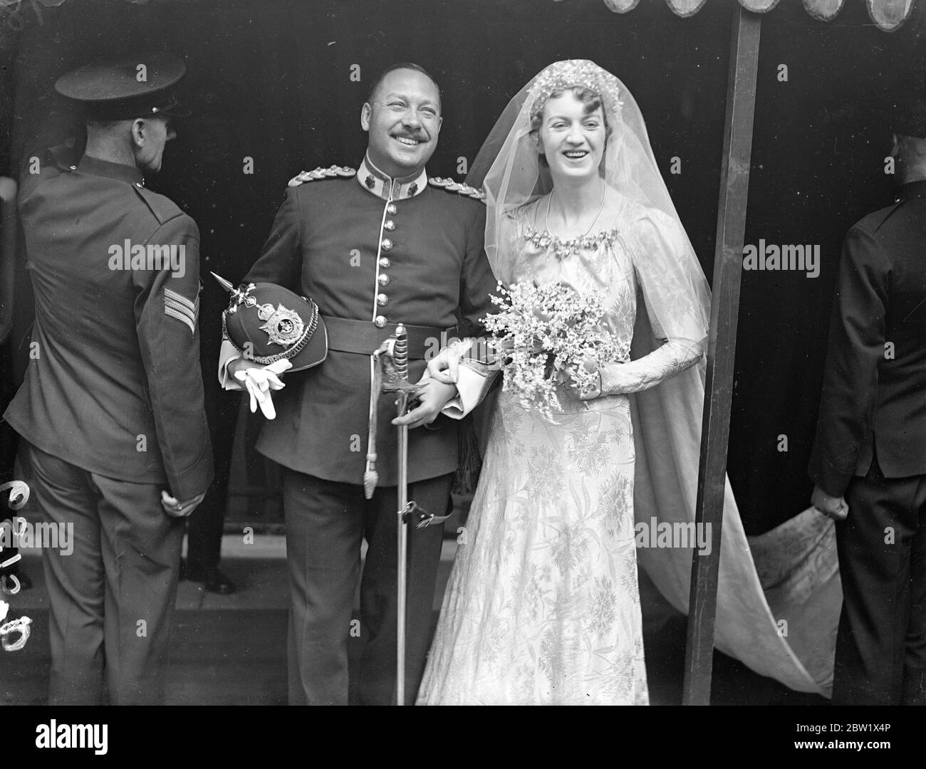 Lady Sylvia Maitland si sposò con Lord Carew a St Margaret's. Lady Sylvia Maitland, unica figlia del conte e contessa di Lauderdale, si sposò alla chiesa di St Margaret, a Westminster, con Lord Carew, il duca di Fanteria leggera della Cornovaglia. La sposa indossava una abito di broccato d'oro e seguiva dodici bridesmaid che indossavano camici di morbido materiale bianco rifiniti con ceneri d'oro per adattarsi all'abito della sposa. [Sposato contemporaneamente al Duca di Windsor. Londra Wedding rush.] Foto: La sposa sorridente e lo sposo dopo la cerimonia. 3 giugno 1937 Foto Stock