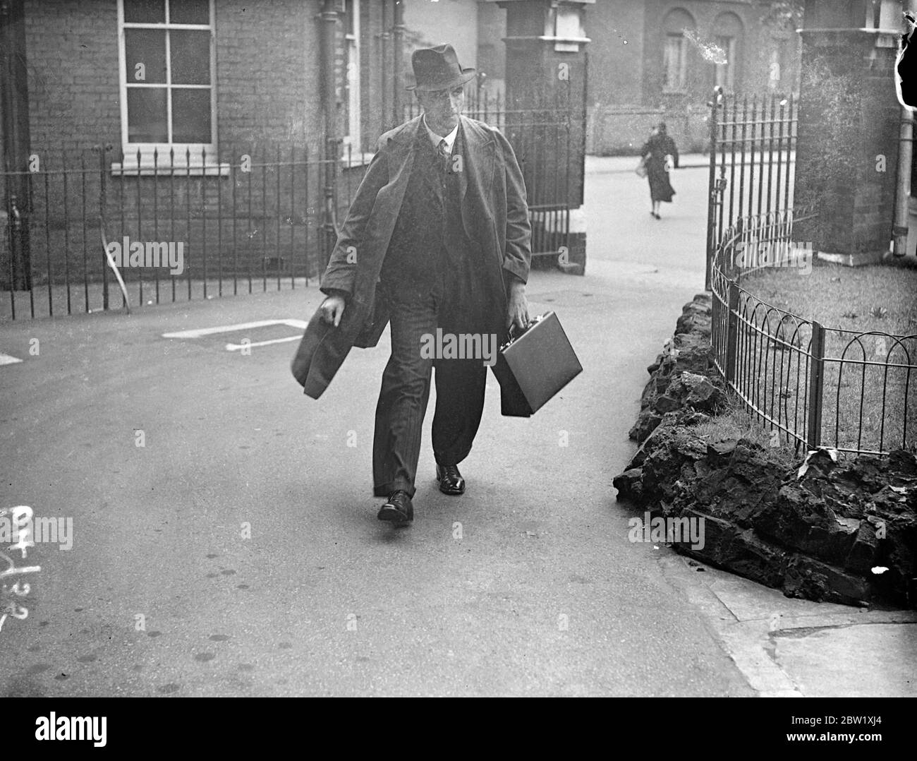 Il detective Inspector prende la pistola per inquisare l'uomo che ha sparato un vicario. L'inquista si aprì al Prince of Wales Hospital, Tottenham, a 26 anni a S Kirby, che si sparò morto dopo aver ferito il Rev C W Sykes, vicario della Chiesa di San Giovanni, Stamford Hill, vicino alla sala della chiesa. Kirby è stato un grande amico del Vicario. Spettacoli fotografici, Detective Inspector Godley arrivo per l'inquest. Sotto il suo mantello è andato che è stato usato nella sparatoria. 22 maggio 1937 Foto Stock