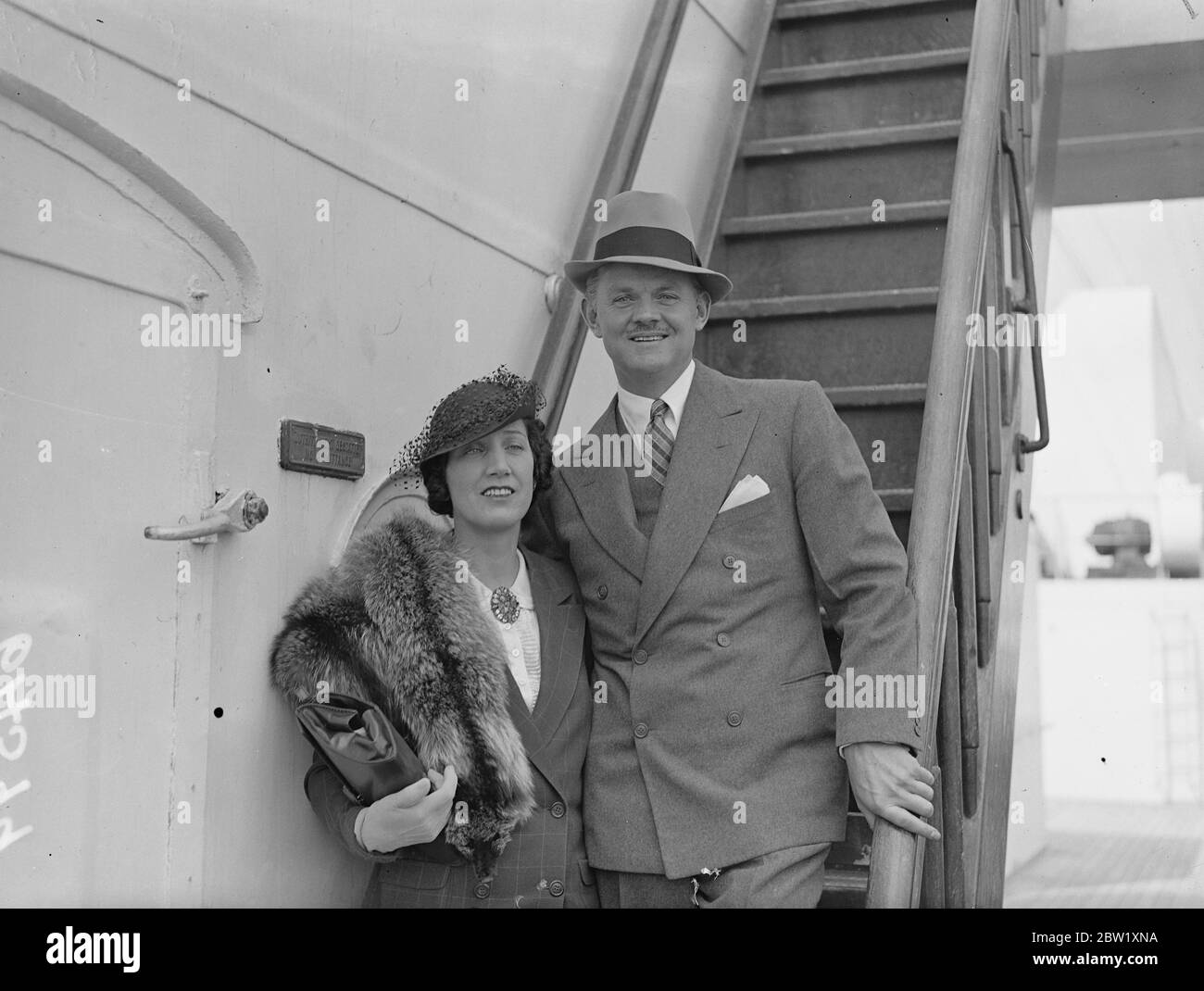 Arriva Lawrence Tibbett. Prima visita del cantante d'opera in Inghilterra. Lawrence Tibbett, baritono della Metropolitan Opera House di New York, e un noto attore cinematografico, arrivò a Southampton, a Brema, per la sua prima visita in Inghilterra. Tibbett debutta a Covent Garden il 14 maggio con il titolo di Scarpia in Tosca e più tardi nella stagione creerà il ruolo di protagonista in Don Juan de Manara , una nuova opera di Eugene Goossens e Arnold Bennett. Spettacoli fotografici: Lawrence Tibbett con sua moglie all'arrivo a Southampton. 10 maggio 1937 Foto Stock