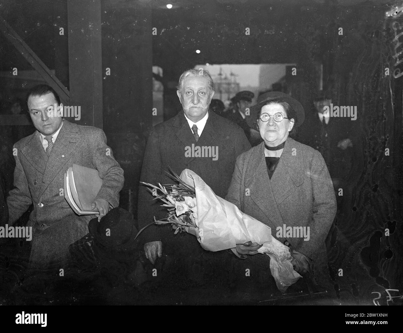 77 anni artista colombiano arriva a Londra per la mostra. Il senor Andres de Santa Maria, 77 anni artista colombiano, uno degli artisti più conosciuti del Sud America, è arrivato alla Victoria Station accompagnato dalla moglie inglese per la sua mostra alle nuove Burlington Galleries, Londra, la prossima settimana. Spettacoli fotografici: Il senore Andres de Santa Maria e sua moglie all'arrivo a Victoria. 14 maggio 1937 Foto Stock