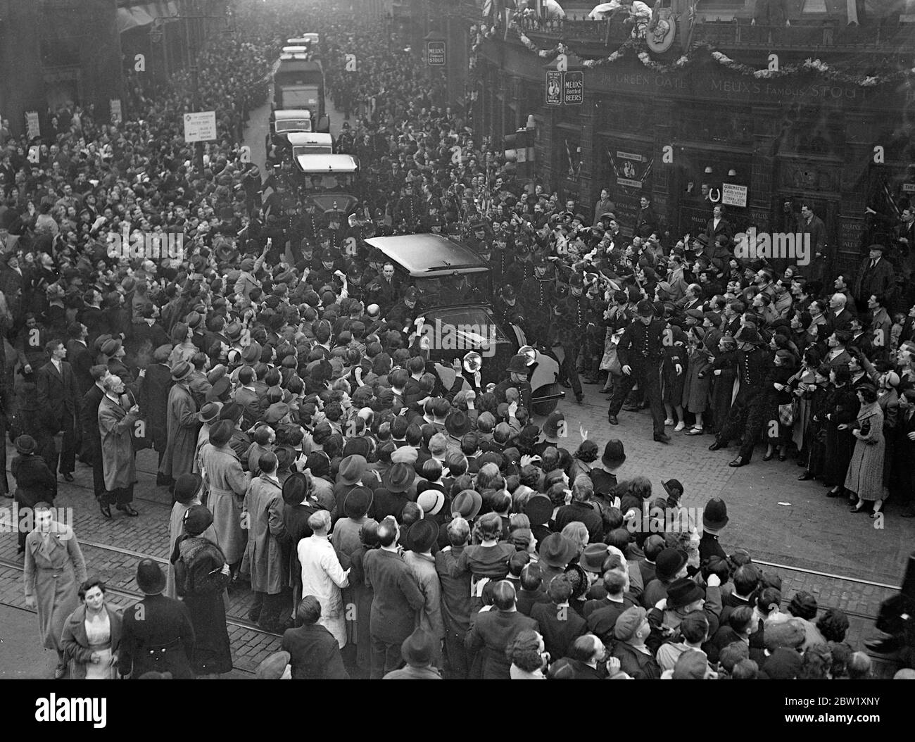 Modo della polizia per auto reale a Hoxton. Il giorno dopo la loro incoronazione, il Re e la Regina fecero un viaggio attraverso le strade decorate dei quartieri più poveri di Londra. Migliaia di persone si riunirono per salutarli e finirono in luoghi in cui la polizia doveva forzare la strada attraverso la folla per la Royal Car. Foto spettacoli: La polizia cerca di forzare un modo per la Royal auto attraverso le folle eccitate a Shepherdess Walk, Hoxton. 13 maggio 1937 Foto Stock