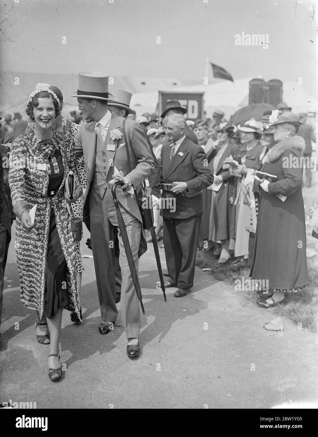 Signore e signora Weymouth ad Ascot. Spettacoli fotografici: Lady Weymouth, con una passeggiata di moda insolita sul corso con Lord Weymouth il secondo giorno dell'incontro Ascot. 16 giugno 1937 Foto Stock