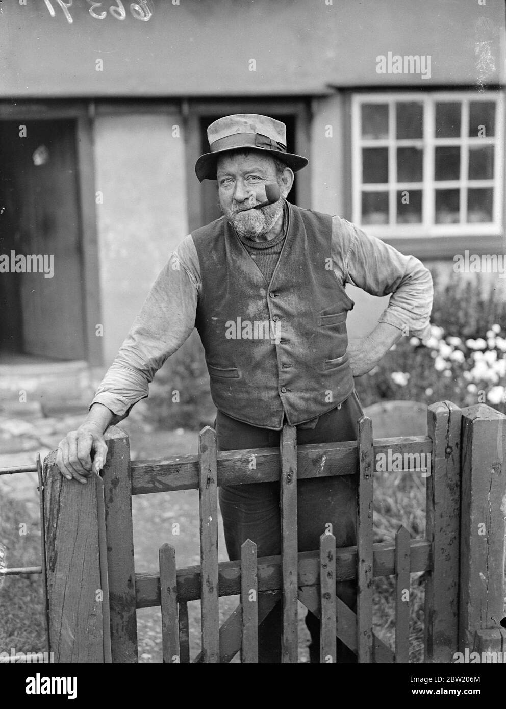 Da una piccola locanda nel pittoresco villaggio Essex di Bardfield, antichi artigiani e personaggi tipici locali sono a trasmettere in America un'impressione di vita rurale inglese come è stato per secoli. Nell'esordiente dell'Aquila diffusa il guaritore locale della verruca, Uppy, due thatcher professionisti e il professor Harold Laski parleranno nel microfono e il mio ospite, il sig. Harry Barnes, chiuderà il programma con ultimi ordini e tempo, gentleman, per favore. Uppy (Charles Shephard Andrews) il guaritore di verruche locale fotografò sopra il suo cancello del giardino. Uppy può curare verruche entro poche settimane senza nemmeno vedere ciao Foto Stock
