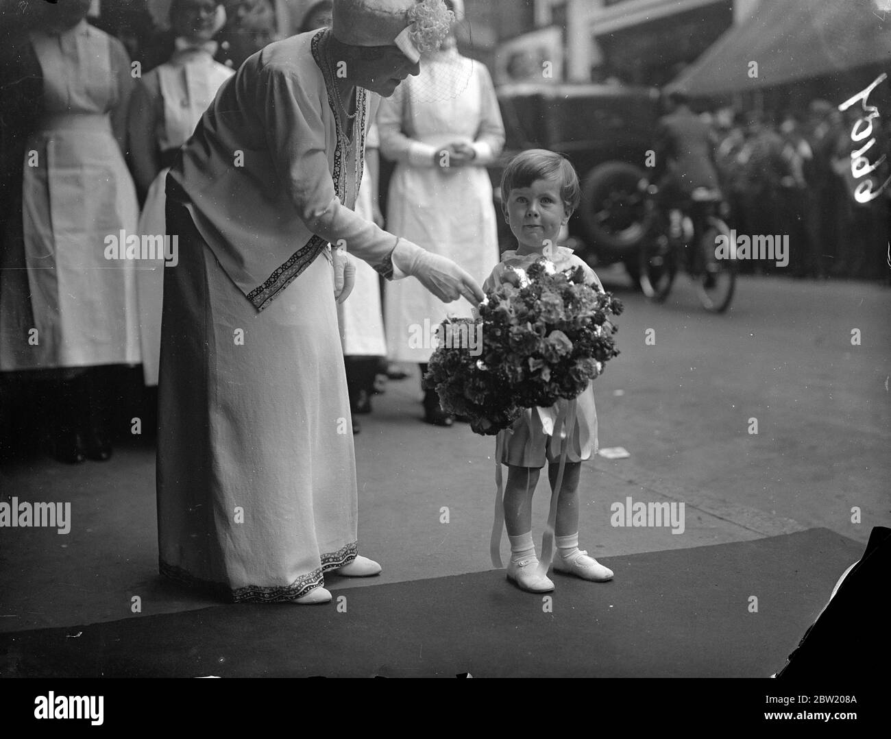 Onorando il loro primo impegno pubblico da solo, la principessa Elizabeth e la principessa Margaret Rose assistono ad una performance degli allievi della Miss Vacani's Dancing Academy all'Ippodromo di Londra in aiuto del South London Hospital for Women. L'on. Victor George Spencer aspetta di presentare bouquet alle Principesse. 30 giugno 1937 Foto Stock