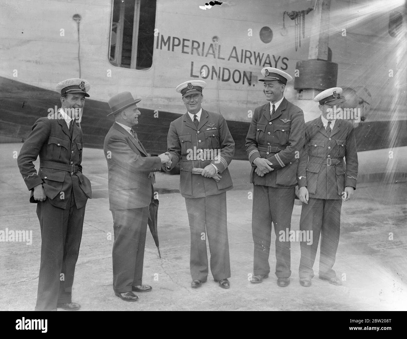 La nave volante della Imperial Airways Caledonia è tornata a Southampton dalla base aerea di Foynes, Irlanda, dopo aver completato la sua prima doppietta sperimentale dell'Atlantico. L'attraversamento dell'oceano di ritorno è stato effettuato in 12 ore e 7 minuti. L'equipaggio [da sinistra a destra: Operatore radio Tommy Valetts, capitano A. S. Wilcockson, primo ufficiale Bowes, e operatore radio Hobbs] è stato accolto dal vice sindaco di Southampton, consigliere Saunders. 17 luglio 1937 Foto Stock