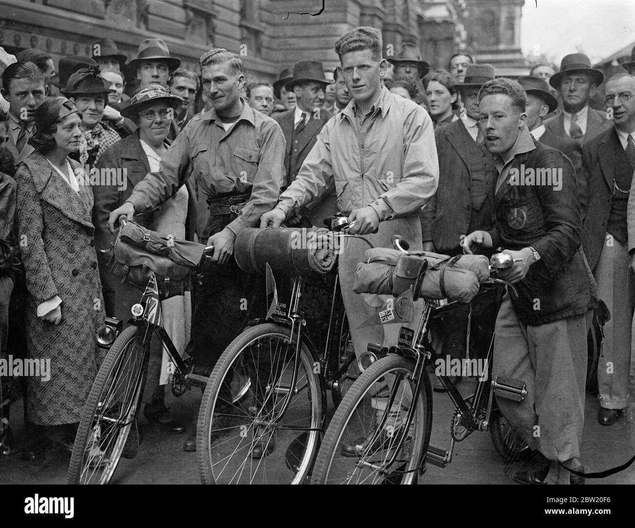 Tre giovani che si recano in Australia come coloni hanno lasciato Downing Street per fare l'intero viaggio in Australia in bicicletta, tranne dove i mari devono essere attraversati. I ciclisti sono circondati da una folla quando hanno lasciato Downing Street (da sinistra a destra): J. Algar, e W. Barber, entrambi 22 e L. Cross, 25. Essi sono assistiti per emigrare dal Consiglio della Chiesa d'Inghilterra dell'insediamento Impero. Sono stati auspicati Godspeed da Malcolm MacDonald, segretario di domini. 1 luglio 1937 Foto Stock