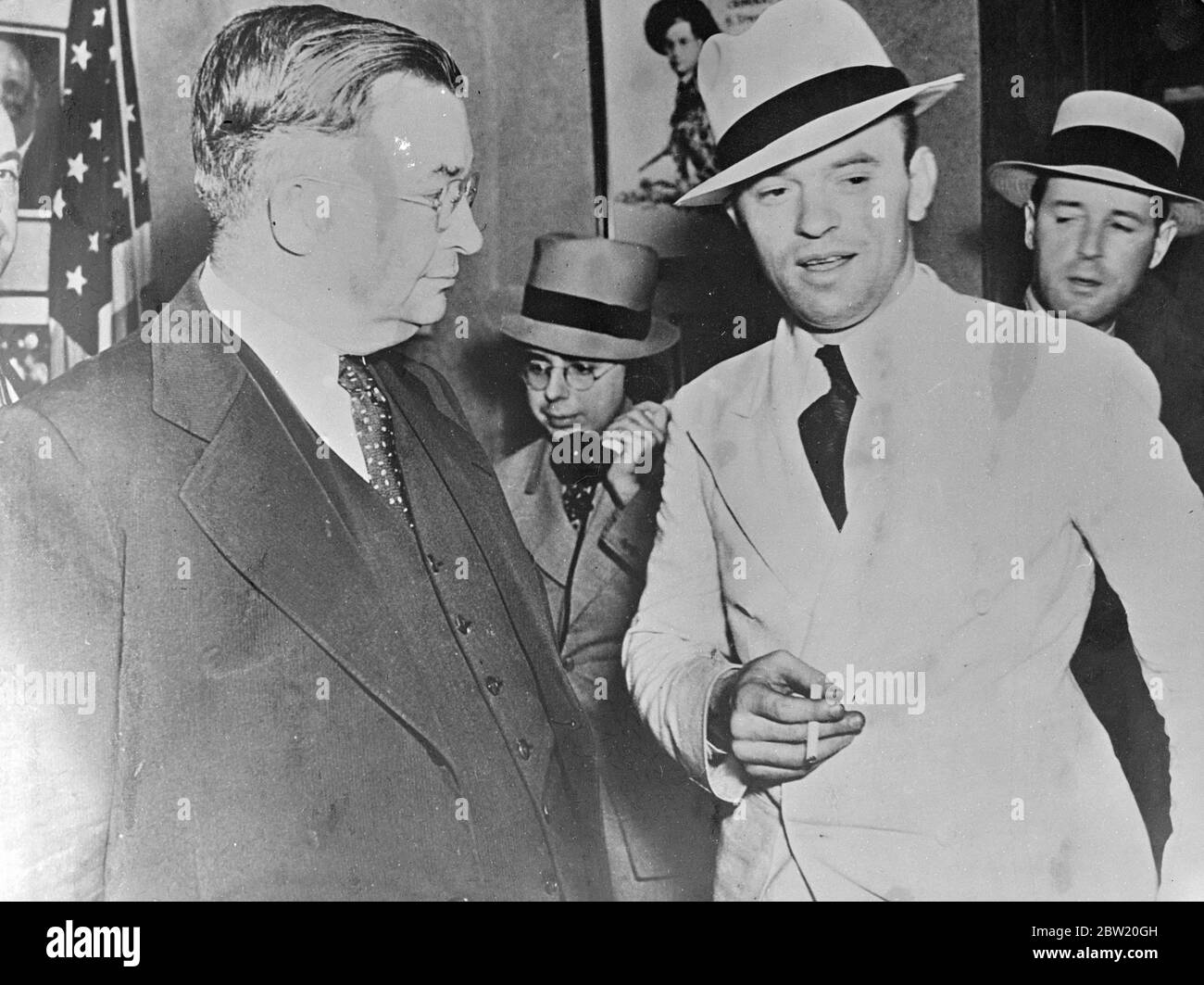 Scultore accusato di triplice omicidio nella sfilata di identità di Chicago. Robert Irwin, scultore di 29 anni, che si dice abbia confessato al triplo omicidio di Veronica Gedeon, modello d'artista, sua madre, e un uomo, è stato arrestato. Irwin era in passato un lodger con i Gedeons, un New York. Le due donne sono state aggredite criminalmente e assassinate nell'uomo, un barbarcaiolo in casa loro, è stato pugnalato attraverso il cervello. Foto mostra, Robert Irwin, (a destra) con lo sceriffo John Toman nella sua prigione della contea di Cook, Chicago, dopo il suo arresto. 5 luglio 1937 Foto Stock