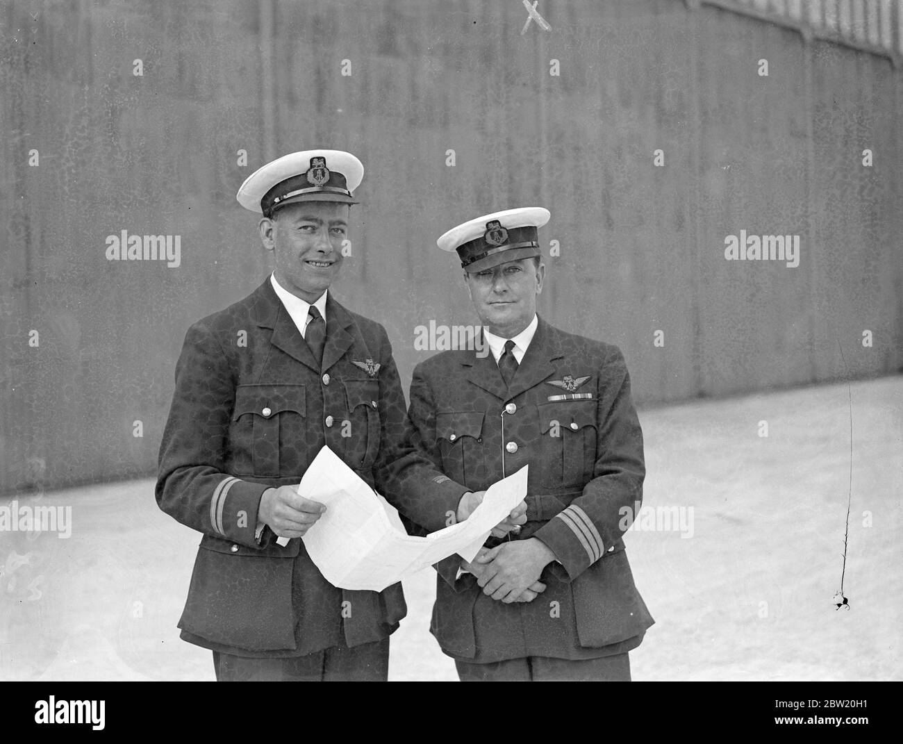 Wilcockson (destra) e primo ufficiale G. H. Bowes studiano la rotta atlantica a Hythe, Southampton in preparazione per il primo attraversamento transatlantico commerciale sperimentale che sarà effettuato dalla nave volante Caledonia la prossima settimana (giugno 24). 18 giugno 1937 Foto Stock