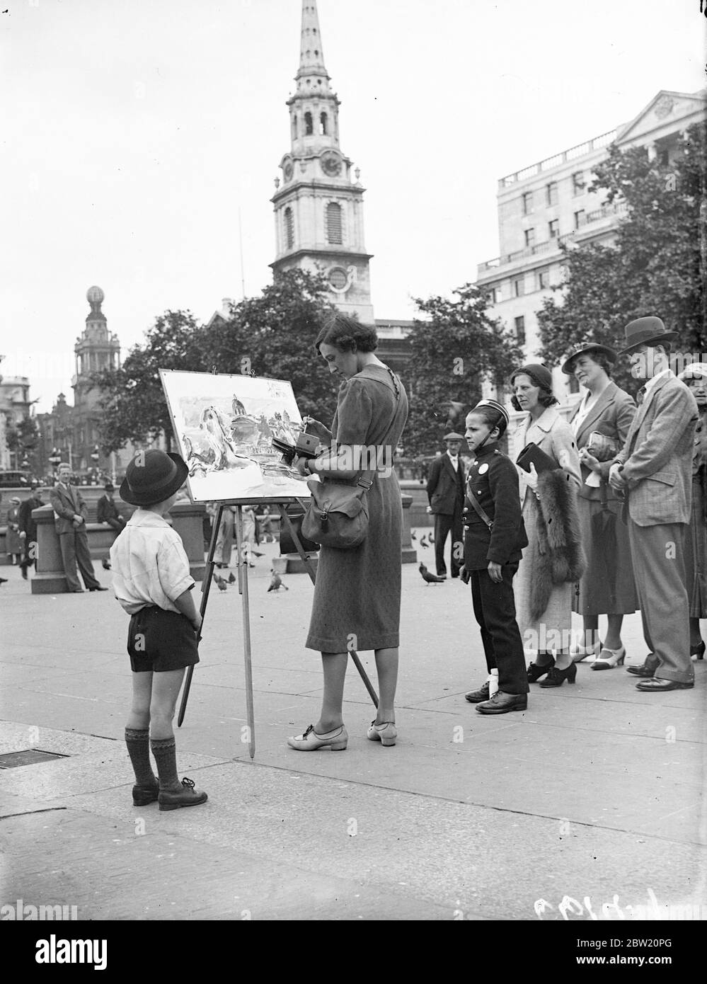 La sig.ra Diana Murray Hill, artista femminile, è il centro di attrazione mentre lavorava in Trafalgar Square. 2 luglio 1937 Foto Stock