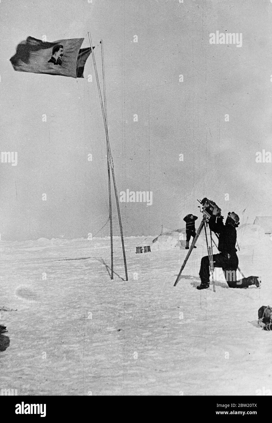 Queste immagini, le prime mai realizzate al Polo Nord, sono state volate a Mosca e da lì a Londra. La spedizione scientifica sovietica guidata dal professor otto Schmidt è riuscita a stabilire su un ghiaccio galleggiante nel deserto congelato da cui preziose informazioni scientifiche e regolari rapporti meteo sono ora inviati per la prima volta dalla radio nella storia. Una bandiera che porta un ritratto di Stalin e la bandiera dell'Unione Sovietica che si affianchano al Polo Nord. Un membro della spedizione è visto che aziona una telecamera cine. 28 giugno 1937 Foto Stock