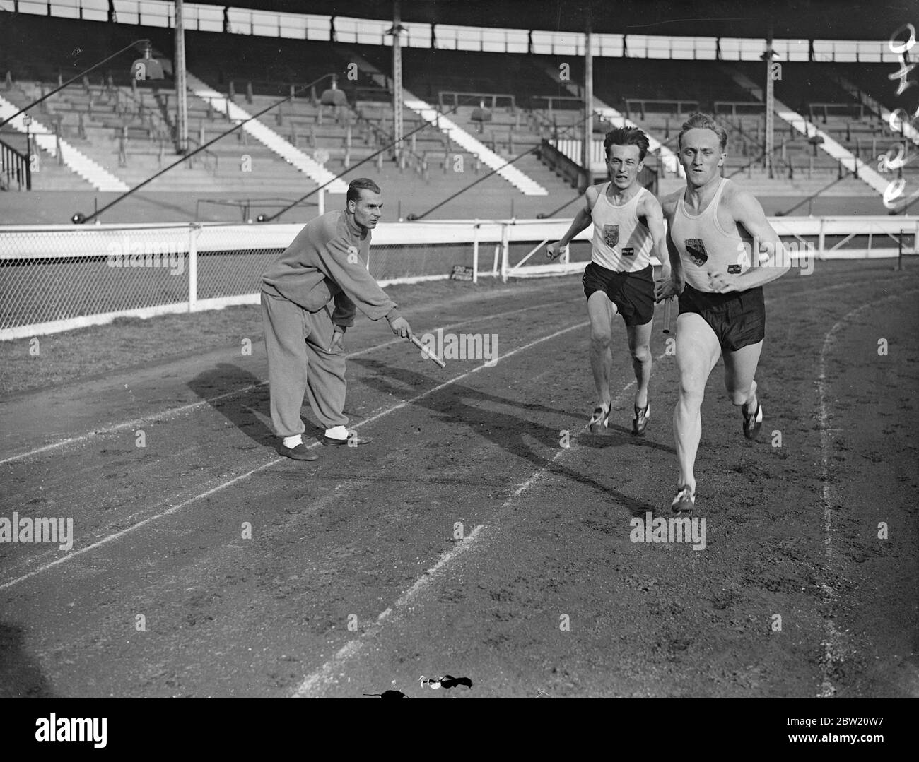 I membri della squadra ungherese si allenano passando il batton per la gara di staffetta sul tracciato della città bianca. Dove sono dovuti partecipare al campionato atletico dilettante. 15 luglio 1937. Foto Stock