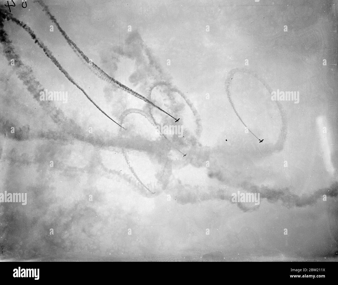 RAF Planes 'grezzi' disegni di fumo alla hendon pageant. Alla presenza del Re e della Regina e di altri membri della Famiglia reale gli ultimi aerei da guerra di Briziano e i migliori piloti hanno dato una mostra emozionante nel pagent annuale della Royal Airforce all'Aerodromo di hendon. Viene visualizzata la foto, il display del filtro fumi. 26 giugno 1937. Foto Stock